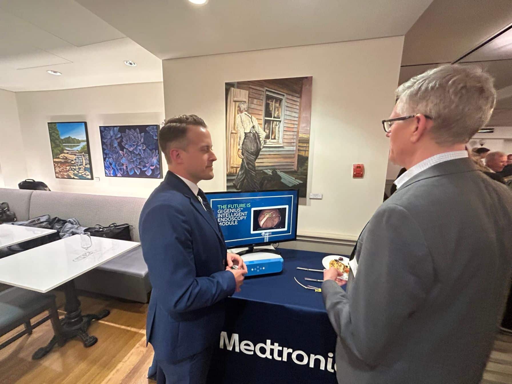 Two men discussing medical technology display