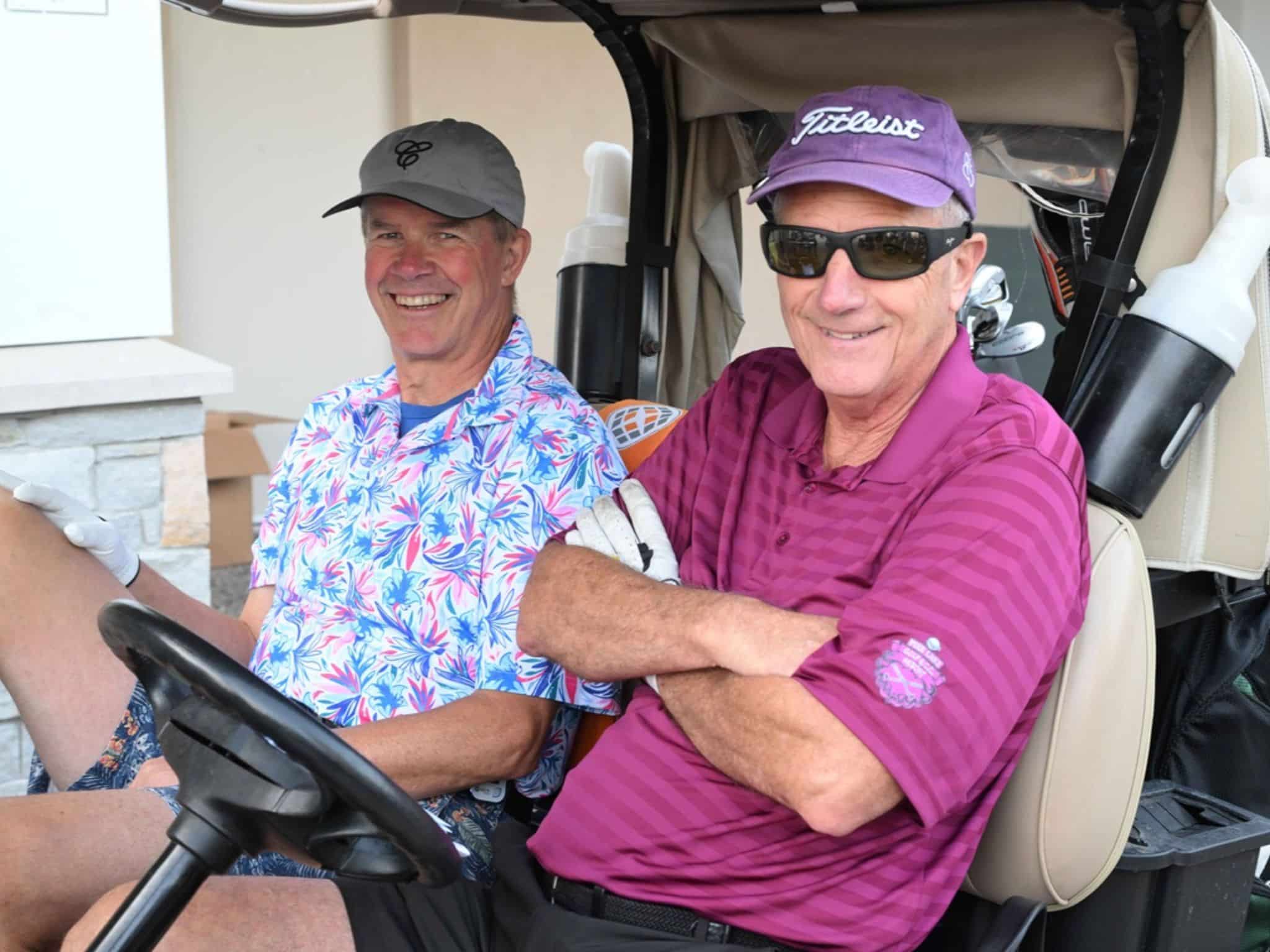 Two men smiling in golf cart
