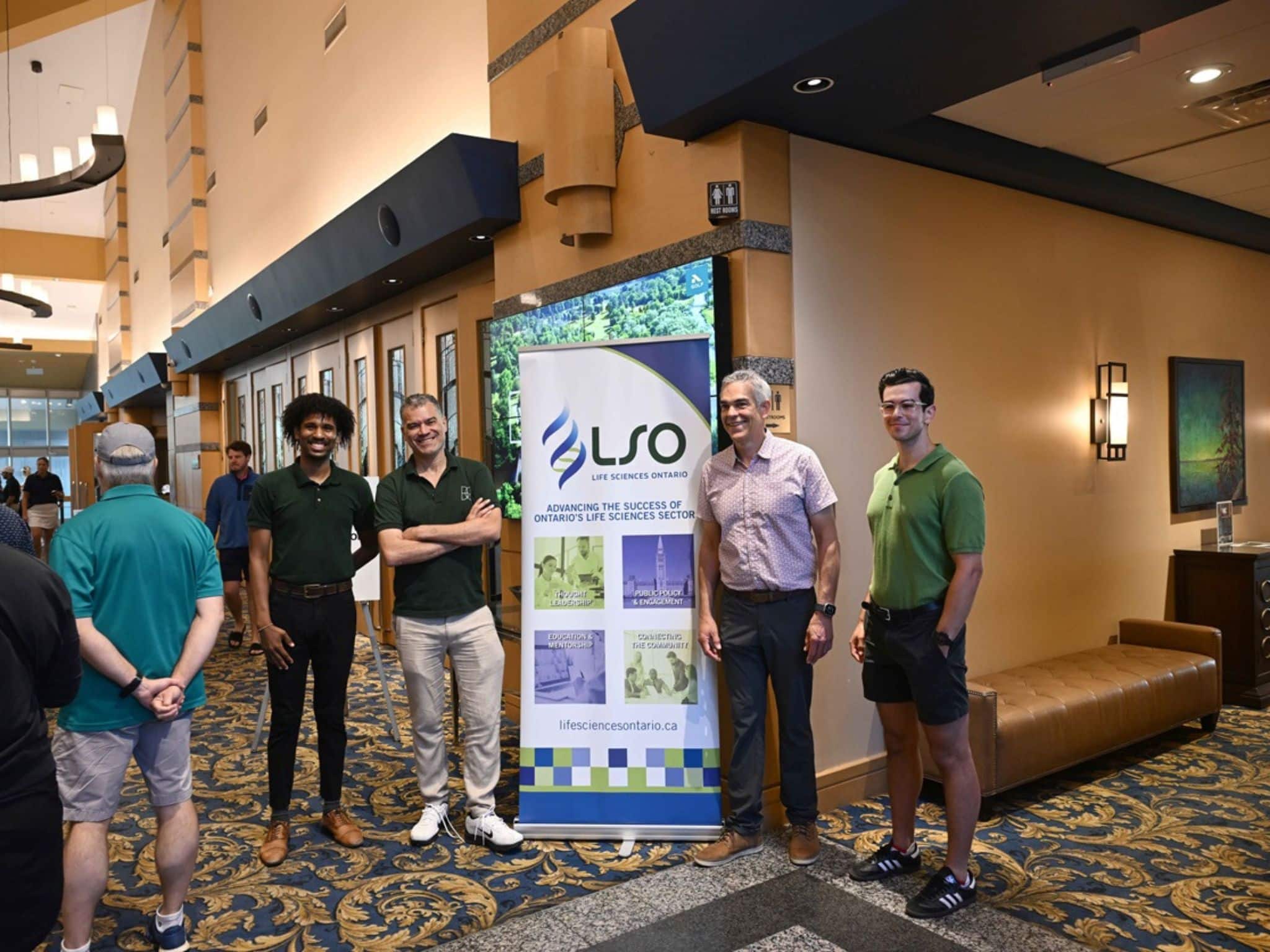 Group of men by promotional banner
