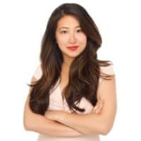 Woman with long hair, arms crossed.