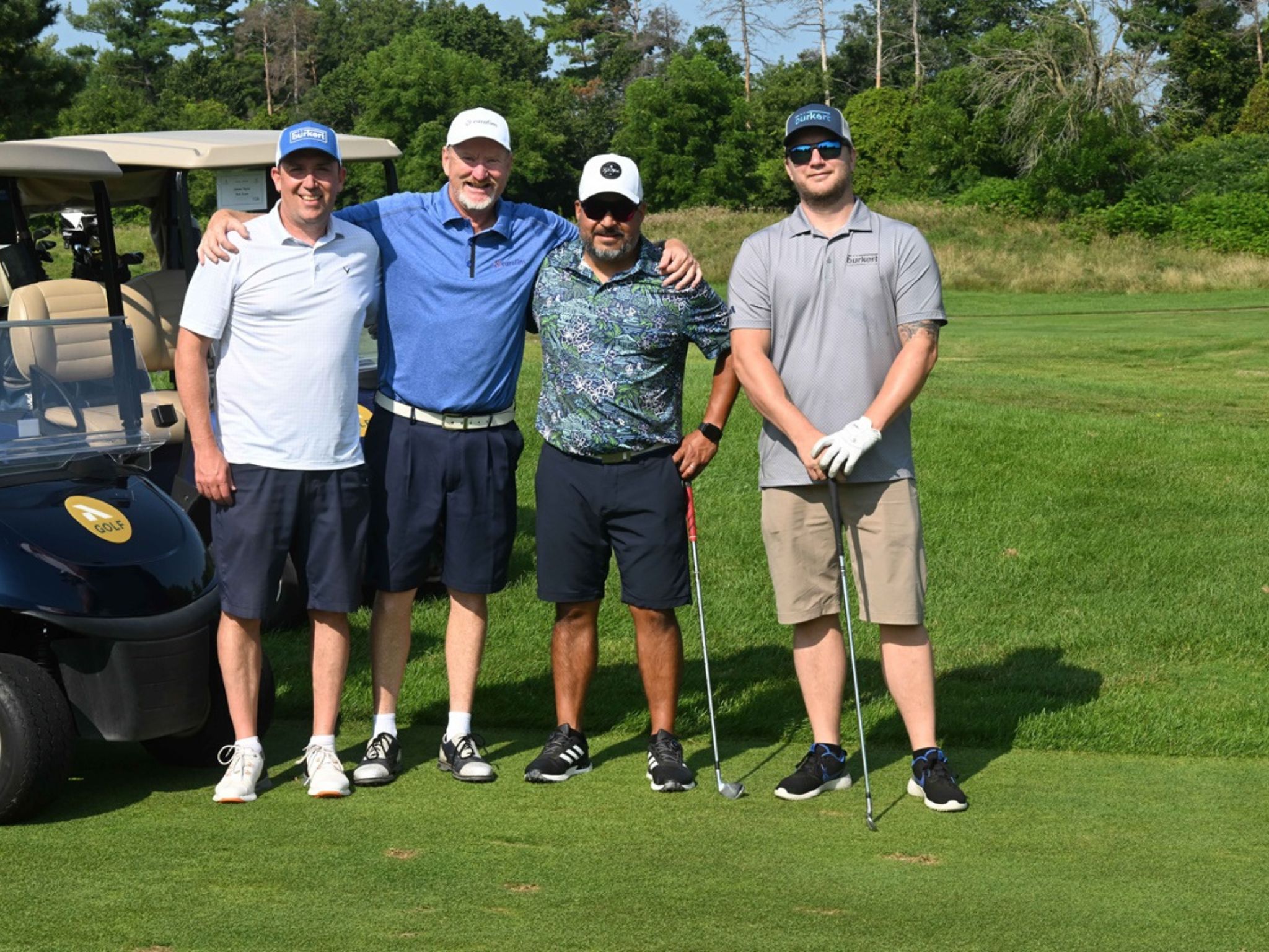 Four men posing on golf course