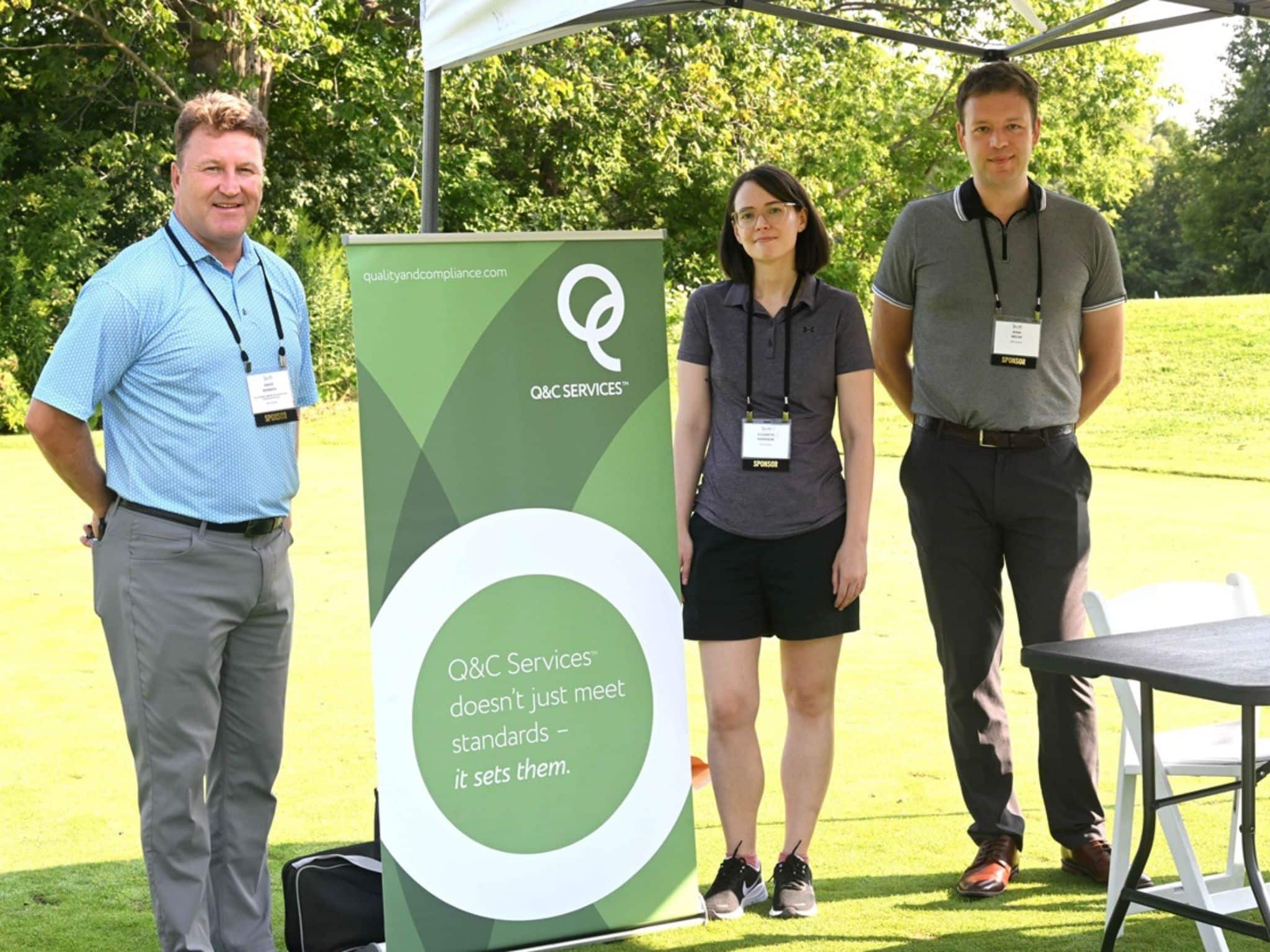 Three people by promotional banner