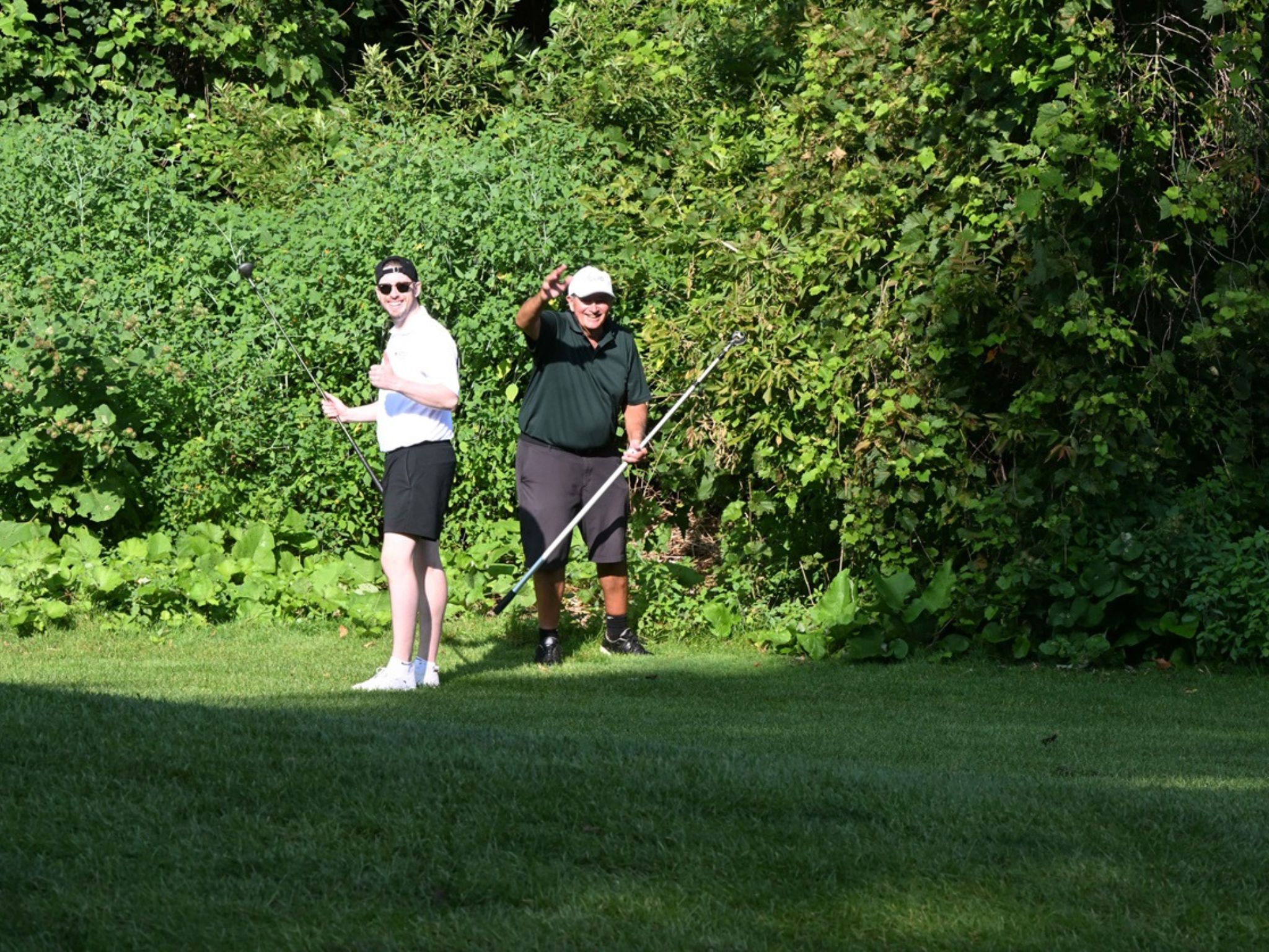 Two golfers posing with thumbs up