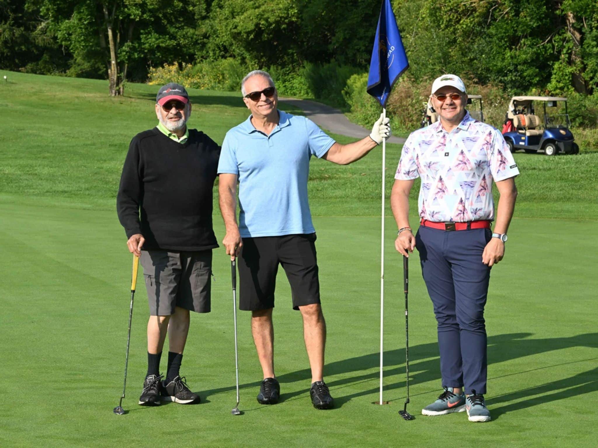 Three men posing on golf course