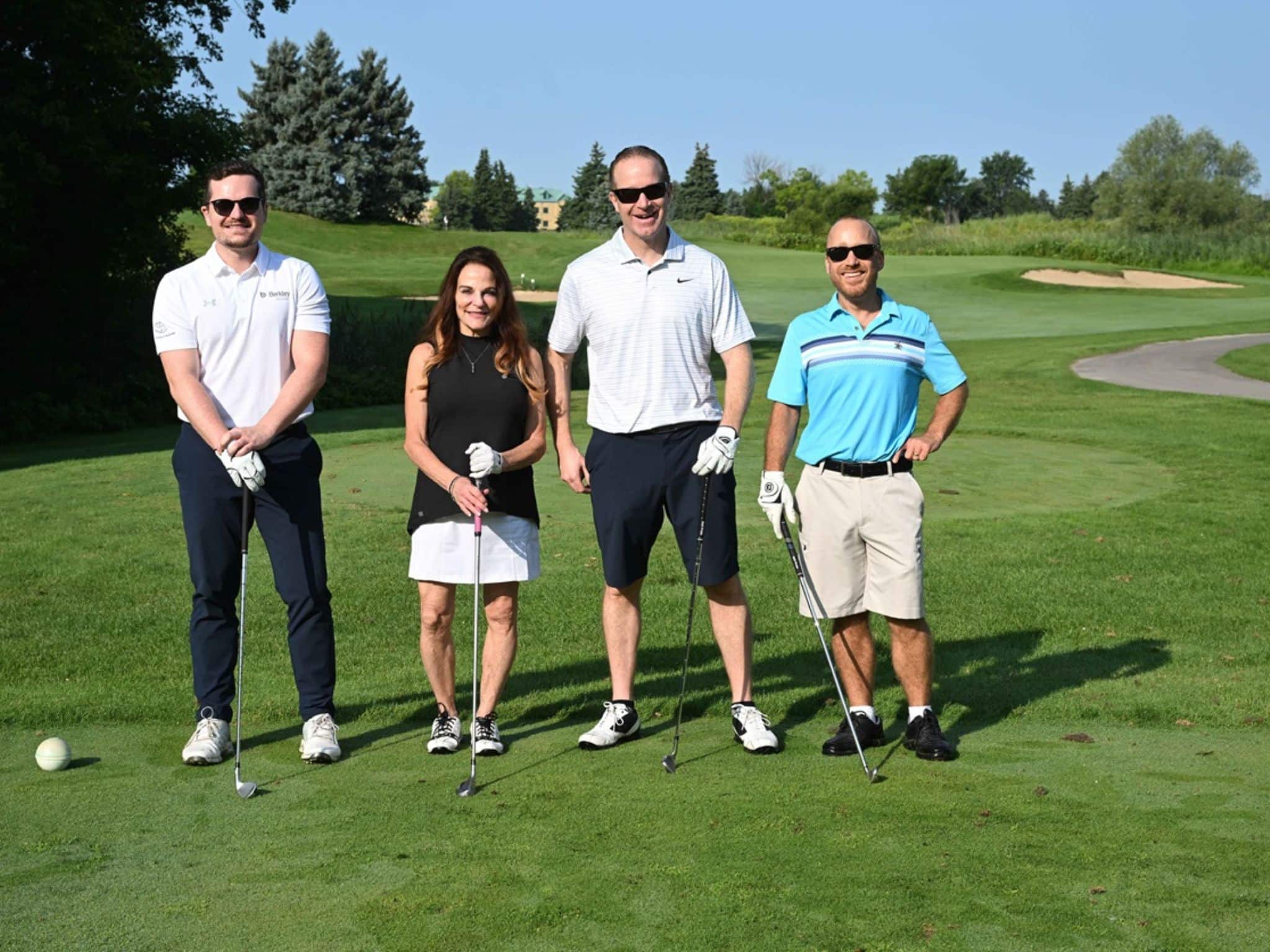 Four golfers posing on course