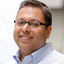 Smiling man with glasses and shirt.
